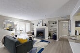 Located at 1901 Briarcliff Rd NE in Atlanta, GA, this single-floor, 2-bedroom, 2-bathroom residence offers a thoughtfully designed layout across a comfortable footprint. The open-concept living area serves as the heart of the home, highlighted by a tile-surround fireplace framed by built-in shelving on both sides — a standout architectural feature that adds both function and character. Light wood-style flooring flows throughout the main living spaces, lending a clean, modern aesthetic. The living room transitions seamlessly into a dedicated dining area, defined by a pendant light fixture and chair-rail molding, and connects to the kitchen via a pass-through window, enhancing the sense of openness. The kitchen features white cabinetry and ample counter space. A dedicated office with large windows and a glass-panel door provides an abundance of natural light and outdoor views of greenery. The spacious primary bedroom is carpeted and includes a generous walk-in closet with multi-level wire shelving. The bathrooms are finished with granite-top vanities, white cabinetry, and tub-shower combinations. A hallway connects the private quarters, keeping the layout efficient and well-organized throughout.