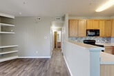 Located at 3597 S Zeno Way in Aurora, CO, this well-appointed 2-bedroom, 2-bathroom single-story home offers a thoughtfully designed layout that maximizes functionality and comfort. The open-concept living, dining, and kitchen area serves as the heart of the home, with durable wood-look flooring flowing throughout. Natural light enters through a sliding glass door in the living room, which also features built-in corner shelving — a practical and distinctive design touch. The kitchen is equipped with warm honey-toned cabinetry, black appliances including a range and refrigerator, a mosaic tile backsplash, and a peninsula that provides additional counter space and casual seating. A dedicated hallway connects the bedrooms and bathrooms, maintaining a clear separation between living and sleeping areas. The primary bedroom offers a comfortable footprint with plush carpet, a large window with outdoor views, and access to a walk-in closet with dual hanging rods. The second bedroom features carpet and a standard closet with bi-fold doors. Both bathrooms include tub/shower combinations and wood-look flooring. Additional highlights include an in-unit laundry area, a utility room, and multiple closets throughout for generous storage. The overall palette of neutral grays and warm beiges creates a clean, move-in-ready ambiance.