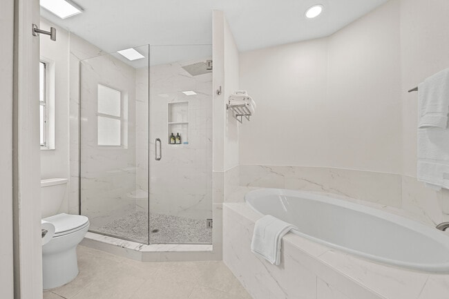 Spa-like feel in the newly renovated bright clean en suite bath with tiled frameless door shower - 2234 Justin Ave