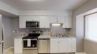 Located at 880 Glendale Dr in Cary, NC, this two-floor home offers a well-organized layout with functional and comfortable living spaces throughout. The kitchen is outfitted with crisp white cabinetry, granite-style countertops, and a full suite of stainless steel appliances including a range, over-the-range microwave, and dishwasher, all set atop light tile flooring. The living and dining areas feature soft neutral carpeting, gray-toned walls with white chair-rail accents, textured ceilings, and ceiling fans for year-round comfort. Sliding glass doors and multiple windows fill the main living space with natural light and provide direct access to the backyard, where mature greenery is visible. The bedrooms are generously sized with plush carpeting, ceiling fans, and ample natural light from large windows overlooking the surrounding landscape. At least one bedroom includes a walk-in closet. The bathrooms are finished with tile flooring, white vanities, and neutral gray walls. A half bath is conveniently located near the entry. The staircase connects both levels seamlessly, and the overall design presents a cohesive, move-in ready home with practical features throughout.