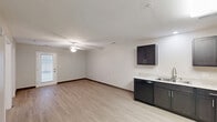 Located at 512 De Roode Street in Lexington, Kentucky, this one-bedroom, one-bathroom unit offers a well-organized, single-floor layout designed for efficient everyday living. Light wood-style flooring and neutral wall tones run throughout, creating a clean, cohesive aesthetic from room to room.

The open-concept living area flows directly into the kitchen, making the space feel connected and practical. The kitchen is outfitted with dark espresso-toned cabinetry, light countertops, and a full suite of black appliances — including a range, dishwasher, refrigerator, and microwave — arranged in an L-shaped configuration that maximizes workspace. A ceiling fan with a light fixture anchors the living area, which benefits from a glass exterior door that invites natural light.

The hallway connects the main living areas to the bedroom, bathroom, and a dedicated laundry room. The bedroom is a comfortable size, featuring a ceiling fan, a window for natural light, and access to a walk-in closet with wire shelving. The bathroom is well-appointed with light-toned flooring, a single vanity with a sink and mirror, and a full tub-shower combination. The in-unit laundry room includes washer and dryer hookups and overhead wire shelving for additional storage.