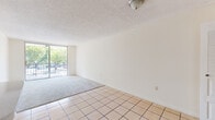 Located in Miami, FL, this single-floor unit at 9060 NW Eighth St offers a practical and well-organized layout suited for comfortable everyday living. The open living and dining area features a combination of light ceramic tile flooring and plush carpeting, with a textured ceiling overhead and a large sliding glass door that leads to a private balcony, allowing abundant natural light and views of the surrounding greenery to flow into the space.

The kitchen is equipped with white cabinetry featuring decorative trim, light countertops, a stainless steel sink, an electric range, and a dishwasher, providing a functional setup for meal preparation. Tile flooring continues throughout the kitchen area.

The bedrooms are carpeted and generously sized, each featuring large windows that frame pleasant outdoor views of the tree-lined surroundings, filling the rooms with natural light. Closet space is available within the unit, as seen near the entryway area.

The bathroom includes a single-sink vanity with white cabinetry, a large wall mirror, and a full tub-shower combination with tile surround. Tile flooring completes the clean, functional design of the space.

Throughout the unit, neutral wall tones and consistent finishes create a cohesive and move-in-ready atmosphere in the heart of Miami.