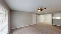 This well-appointed single-story home offers three bedrooms and two full bathrooms, thoughtfully designed for comfortable everyday living. The living areas are finished with soft, neutral-toned carpeting and painted in a calming gray palette that carries throughout the home, creating a cohesive and inviting atmosphere. Ceiling fans are present in the living room and all bedrooms, ensuring year-round comfort. The spacious living area flows naturally through the layout, with windows dressed in horizontal blinds that allow for controlled natural light and outdoor views of surrounding greenery. The kitchen is a standout feature, showcasing white shaker-style cabinetry, granite countertops, a stainless steel sink, and stainless steel appliances including a dishwasher and range. Wood-look flooring in the kitchen adds warmth and durability. Both bathrooms are well-finished, featuring white vanity cabinetry with granite countertops, framed mirrors, and wood-look tile flooring. The bathrooms include a tub-shower combination with full tile surround in a rich gray tone. The bedrooms are generously sized, each offering ample space and natural light, making them versatile for a variety of uses.