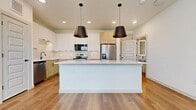 This 1,330 sq ft two-story home in Argyle, TX offers 1 bedroom and 3 bathrooms across two well-designed floors. The main level (480 sq ft) features an open-concept kitchen and living area with light wood flooring, a large center island with quartz countertops, stainless steel appliances, two-tone cabinetry, a tile backsplash, and bold pendant lighting. Upstairs (860 sq ft), the living room includes a built-in arched desk nook and recessed lighting. The 150 sq ft primary bedroom features plush carpet, a ceiling fan, and natural light. The primary bath offers a soaking tub, glass-enclosed shower, and wood-look flooring. Two closets provide ample storage.