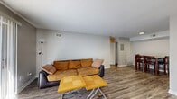 This single-floor residence offers a functional and well-organized layout across two bedrooms and two bathrooms. The living room serves as the central gathering space, featuring durable wood-style laminate flooring, neutral gray walls, a textured ceiling, and a sliding door that invites natural light. It flows naturally into the dining area, which is defined by the same laminate flooring and provides a dedicated space for a dining table and chairs, with a louvered closet adding convenient storage nearby.

The kitchen is efficiently designed in a galley-style configuration, outfitted with rich wood cabinetry, gray countertops, and a full suite of appliances including a stainless steel refrigerator, electric range, and built-in microwave. The layout maximizes workspace while maintaining a compact and practical footprint.

Both bedrooms are comfortably sized and finished with plush carpet flooring and neutral wall tones. The primary bedroom is generously proportioned, offering ample space and a ceiling fan with light fixture. A dedicated closet accessible from the hallway provides additional storage. The second bedroom features its own window with blinds for natural light and privacy. The hallway connects all rooms cohesively, completing this thoughtfully laid-out home.