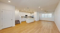 Located at 2350 N Narcoossee Rd in Saint Cloud, Florida, this two-story home offers a well-designed layout spread across two floors. The main level features an open-concept living area where the kitchen, dining, and living room flow seamlessly together, all finished with light wood-tone flooring that enhances the bright, airy atmosphere. The kitchen is a standout, boasting white shaker-style cabinetry, a tiled backsplash, stainless steel appliances, and a center island with quartz countertops and an undermount sink — ideal for both cooking and casual dining. Recessed lighting and pendant fixtures add warmth throughout. A ceiling fan in the living area and large windows allow for natural light. The main level also includes a pantry and access to a covered patio with a classic brick paver surface, as well as a gated side entry. Upstairs, three bedrooms offer comfort and privacy, each with light flooring and ample natural light. The generously sized primary bedroom includes a walk-in closet with wire shelving systems. Four bathrooms serve the home, providing convenience across both floors. A dedicated laundry room with washer and dryer, a utility room, and an attached garage round out the practical offerings of this well-appointed Florida home.