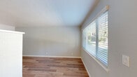 Located at 859 University Ave in Los Gatos, CA, this well-appointed 2-bedroom, 1-bathroom unit offers a thoughtfully designed single-floor layout. Warm hardwood-style flooring flows consistently throughout the space, lending a cohesive and inviting aesthetic to every room.

The combined kitchen and living area forms the heart of the unit. The kitchen is outfitted with crisp white shaker cabinetry, white quartz-style countertops, and a full suite of stainless steel appliances including a range, over-the-range microwave, dishwasher, and refrigerator. The living room benefits from a large sliding window that fills the space with natural light and offers views to the outdoors.

The primary bedroom is generously sized, featuring mirrored sliding closet doors that enhance the sense of space, plantation shutters, and abundant natural light. The second bedroom is bright and comfortable, with dual windows, wainscoting detail, and a ceiling fan. Both bedrooms continue the warm flooring found throughout the unit.

The bathroom features tile flooring, white cabinetry with a granite-topped vanity, and a shower enclosure. A connecting hallway ties all rooms together efficiently. With its clean, neutral palette and modern finishes, this Los Gatos unit offers a bright and functional living environment.