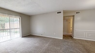 Located at 617 Hampton Cove in Jackson, MS, this single-story, one-bedroom, one-bathroom unit offers a functional and straightforward layout across a compact but well-utilized footprint. Neutral, warm-gray walls and wall-to-wall carpeting flow consistently through the living room, hallway, and bedroom, creating a cohesive and understated aesthetic throughout.

The living room is a generously proportioned open space with a textured ceiling, ceiling-mounted HVAC vents, and neutral carpeting. It connects seamlessly through a hallway to the remaining rooms. Adjacent to the kitchen, the dining area stands out with elegant raised-panel wainscoting along its lower walls and a ceiling-mounted light fixture, adding a subtle decorative touch to the space. The kitchen transitions to hardwood-style flooring and includes white cabinetry, a stainless steel refrigerator, and a sink with an under-cabinet workspace.

The bedroom is a well-sized room featuring a ceiling fan with a light fixture and a large window that allows natural light and outdoor views of surrounding greenery. The full bathroom includes a tiled tub-shower combination, a toilet, and hardwood-style flooring. A dedicated closet and hallway complete the layout, offering practical storage and circulation throughout the unit.