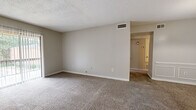 Located at 617 Hampton Cove in Jackson, MS, this single-story, one-bedroom, one-bathroom unit offers a functional and straightforward layout across a compact but well-utilized footprint. Neutral, warm-gray walls and wall-to-wall carpeting flow consistently through the living room, hallway, and bedroom, creating a cohesive and understated aesthetic throughout.

The living room is a generously proportioned open space with a textured ceiling, ceiling-mounted HVAC vents, and neutral carpeting. It connects seamlessly through a hallway to the remaining rooms. Adjacent to the kitchen, the dining area stands out with elegant raised-panel wainscoting along its lower walls and a ceiling-mounted light fixture, adding a subtle decorative touch to the space. The kitchen transitions to hardwood-style flooring and includes white cabinetry, a stainless steel refrigerator, and a sink with an under-cabinet workspace.

The bedroom is a well-sized room featuring a ceiling fan with a light fixture and a large window that allows natural light and outdoor views of surrounding greenery. The full bathroom includes a tiled tub-shower combination, a toilet, and hardwood-style flooring. A dedicated closet and hallway complete the layout, offering practical storage and circulation throughout the unit.