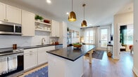 Located at Waters Edge Village in Charlotte, NC, this thoughtfully designed one-bedroom, one-bathroom residence offers a cohesive open-concept layout that maximizes both functionality and comfort. The combined kitchen and living area serves as the heart of the home, featuring light wood-style flooring throughout and an abundance of natural light. The kitchen is outfitted with white shaker cabinetry, dark countertops, a subway tile backsplash, stainless steel appliances including a French door refrigerator, and a central island with pendant lighting in warm brass tones — ideal for both cooking and casual dining. The living area flows seamlessly toward a glass door that opens to a private balcony, offering serene waterfront views. The bedroom continues the bright, airy aesthetic with large windows that frame picturesque water views, providing a tranquil retreat. The full bathroom features a glass-enclosed walk-in shower, a dual-sink vanity with white cabinetry, and wood-look flooring that ties the space together. A dedicated closet provides practical storage. The overall ambiance is modern and welcoming, with clean lines and thoughtful finishes throughout.