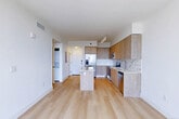 Located at 4465 Griffin Rd in Dania Beach, FL, this contemporary residence offers a thoughtfully designed open-concept layout that seamlessly connects the living room, dining area, and kitchen. Light wood-tone flooring flows throughout the space, complementing the bright white walls and creating a clean, modern aesthetic. The kitchen is a standout feature, showcasing warm wood cabinetry that extends floor to ceiling, a marble-style tile backsplash, quartz countertops, stainless steel appliances, and a central island that serves as both a prep space and casual dining area. Track lighting overhead adds a refined touch. The living area is bathed in natural light courtesy of a floor-to-ceiling glass slider that opens directly onto a private balcony, offering sweeping open-air views of the Dania Beach skyline and surrounding landscape. The bedroom mirrors this connection to the outdoors with its own large glass door and balcony access, flooding the room with light. The bathroom features marble-tiled walls in the glass-enclosed shower, a wood-front vanity with a white quartz countertop, and neutral tile flooring. Additional highlights include four closets, an in-unit laundry area, and a well-connected hallway. This residence combines modern finishes with functional design in a prime South Florida location.