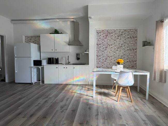 “Bright, modern full kitchen with induction cooktop, stainless hood, and spacious dining area. - 3058 Galloping Hills Rd