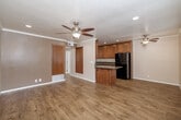 Located in San Diego, CA, this single-floor, 2-bedroom, 1-bathroom home offers a functional and well-appointed layout. The living room features warm hardwood-style flooring, crown molding, recessed lighting, and a ceiling fan, creating a bright and comfortable gathering space. Adjacent to the living area, the dining room flows seamlessly into the kitchen, which is a standout feature of the home. The kitchen is equipped with rich medium-toned wood cabinetry, dark granite countertops, a granite-topped island, black appliances including a gas range, built-in microwave, and refrigerator, as well as a stainless steel sink — providing ample functionality and storage. Both bedrooms are finished with plush carpeting, ceiling fans, and windows that allow natural light and outdoor views. Each bedroom includes dedicated closet space, with one featuring a walk-in closet. The full bathroom is well-appointed with tile flooring, wood cabinetry with granite countertop, a combined tub and shower with sliding glass doors, and clean, neutral finishes throughout. A utility room and hallway complete the layout, adding practical storage and connectivity. The home offers a cohesive, comfortable design throughout.