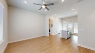 Located at 2600 Lake Forest Dr in McKinney, TX, this well-appointed 2-bedroom, 2-bathroom residence offers a thoughtfully designed single-floor layout with a clean, contemporary aesthetic. Warm wood-look flooring runs throughout the entire space, complemented by neutral walls and abundant natural light from multiple windows fitted with white blinds.

The open-concept living and kitchen area forms the heart of the home. The kitchen is equipped with stainless steel appliances — including a side-by-side refrigerator, electric range, and over-the-range microwave — grey shaker-style cabinetry, white quartz countertops, a subway tile backsplash, and a central island with pendant lighting overhead. A ceiling fan with integrated lighting anchors the living area.

Both bedrooms are comfortably sized with ceiling fans, multiple windows for natural light, and continued wood-look flooring. The primary bedroom includes a dedicated walk-in closet with built-in rod shelving. The bathrooms are finished with white vanity cabinetry, quartz countertops, and large-format tile surround tub-shower combinations.

A dedicated laundry area houses a full-size front-load washer and dryer with overhead shelving, adding practical convenience to this well-rounded residence.