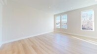 Located at 775 Morton St E in Boston's Mattapan neighborhood, this single-floor unit offers a well-planned layout with a bright, contemporary interior. Light hardwood flooring runs consistently throughout the space, complementing the neutral warm-beige walls and crisp white trim that define the overall aesthetic.

The living areas are generously proportioned, featuring large double-hung windows that flood the rooms with natural light and offer views of the surrounding neighborhood. Recessed lighting provides additional illumination in select areas, enhancing the clean, modern feel.

The kitchen is well-appointed with white shaker-style cabinetry, light countertops, and a full suite of stainless steel appliances, including a dishwasher, electric range, and over-the-range microwave. A gold-finished faucet at the undermount sink adds a refined touch. A louvered closet door near the kitchen entry provides convenient storage.

The additional rooms are bright and versatile, each benefiting from natural light through well-positioned windows. The bathroom features a full tub-shower combination with a clean white surround and marble-look tile flooring. Throughout the unit, the consistent finishes and thoughtful design create a cohesive, move-in-ready living environment.