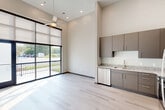 Located at 1446 Central Ave in Chattanooga, TN, this modern one-bedroom, one-bathroom unit offers a thoughtfully designed open-concept layout. The combined kitchen and living area is a standout feature, boasting impressively high ceilings and large floor-to-ceiling windows fitted with roller shades that flood the space with natural light. A sliding glass door opens directly onto a private balcony with metal railing, offering pleasant outdoor views. Light-toned hardwood-style flooring runs throughout, enhancing the bright, airy ambiance, while a ceiling fan adds both style and function.

The kitchen is well-appointed with taupe flat-front cabinetry, granite countertops, a gold-toned faucet, and a full suite of stainless steel appliances including a refrigerator, electric range, microwave, and dishwasher — providing ample storage and functionality.

The bedroom is a comfortable, private retreat, accompanied by a dedicated closet for storage. The bathroom features matching taupe cabinetry, granite countertops, a vessel sink, and a full bathtub and shower combination with tile surround. A dedicated laundry area completes the unit, offering added everyday convenience. The overall design is clean, contemporary, and efficiently organized.