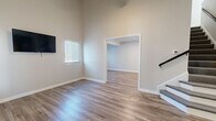 Located at 10710 Beaver Dam Rd in Cockeysville, MD, this two-story, 2-bedroom, 3-bathroom home offers a thoughtfully designed layout with modern finishes throughout. The main floor serves as the heart of the home, featuring an open-concept kitchen and living area with impressively high ceilings that lend an airy, spacious feel. The kitchen is outfitted with slate-blue shaker cabinets, marble-style countertops, under-cabinet lighting, and a full suite of stainless steel appliances including a refrigerator, dishwasher, microwave, and range. Light-toned luxury vinyl plank flooring runs seamlessly throughout both floors, complementing the neutral wall palette. The living area receives natural light through multiple windows fitted with blinds. Upstairs, vaulted ceilings continue the sense of volume, with the hallway overlooking the lower level via an open railing. The primary bedroom features vaulted ceilings, two windows, and ample natural light. The second bedroom also benefits from vaulted ceilings and a bright window. The three bathrooms are finished with white subway tile surrounds accented by neutral mosaic tile borders, granite-style vanity tops, and wood-look flooring, delivering a clean, contemporary aesthetic throughout.