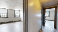 Located at 35 Union St in New London, Connecticut, this single-floor unit offers a practical and functional layout across multiple rooms. Throughout the space, light-toned laminate wood flooring provides a clean, consistent aesthetic, complemented by neutral gray and white walls and drop tile ceilings.

The kitchen is well-appointed with gray cabinetry, granite-style countertops, a white tile backsplash, and stainless steel appliances including a refrigerator, range, and hood vent — providing a modern, move-in-ready cooking space.

Multiple individual rooms are accessible via paneled gray interior doors. Each room features baseboard heating, ample wall space, and access to natural light through windows fitted with horizontal blinds. Several rooms offer views of the surrounding New London streetscape and skyline, with some rooms benefiting from dual-window configurations that enhance brightness.

The bathroom includes tile flooring, a full tub/shower combination with a curtain rod, a toilet, and a small vanity — all finished in a clean, simple style.

A connecting corridor ties the rooms together, creating a cohesive flow throughout the unit. The overall layout and neutral finishes make this space well-suited for a variety of uses, from residential occupancy to professional or multi-purpose applications.