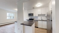 Located at 1330 Danforth Road, Suite 308 in Toronto, this one-bedroom, one-bathroom unit offers a well-designed layout across a single floor. Light-toned laminate flooring runs throughout the space, creating a cohesive and clean aesthetic.

The open-concept kitchen and living area forms the heart of the unit. The kitchen is thoughtfully appointed with white shaker-style cabinetry extending to the ceiling, a classic white subway tile backsplash, dark countertops, and a full suite of stainless steel appliances including a refrigerator, electric range, built-in microwave, and dishwasher. A peninsula provides additional counter space and separates the kitchen from the living area. The living room is bright and airy, featuring large sliding glass doors that open to a balcony, alongside an additional window that draws in natural light and offers views of the surrounding neighbourhood.

The bedroom is a comfortable, well-proportioned room with a window and baseboard heating, finished with the same warm laminate flooring. A bold black interior door adds a modern contrast to the crisp white walls.

The bathroom is clean and functional, featuring subway tile surround in the tub and shower area, grey floor tiles, and a white vanity. A hallway connects the main living spaces, completing this practical and attractive urban unit.