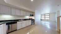 Located at 1043 Yerba Buena Ave in Emeryville, California, this two-floor residence offers a clean, modern design with a neutral color palette throughout. The kitchens are well-appointed with white shaker-style cabinetry extending to the ceiling, dark countertops, and a full suite of stainless steel appliances including a gas range, microwave, dishwasher, and refrigerator. Under-cabinet lighting adds functional brightness to the workspace. The open living areas feature highly polished concrete-style flooring that reflects natural light, contributing to an airy and spacious feel. Large multi-pane windows frame views of surrounding greenery, while a full-length glass entry door allows additional light to flow into the space. The bedrooms are finished with soft wall-to-wall carpeting and tall windows fitted with blinds, offering a quiet, comfortable retreat. Two full bathrooms are present across the floors, each featuring a soaking tub with shower surround, built-in shelving, and clean white finishes. The overall ambiance of the residence is bright, functional, and contemporary, with consistent design elements carried throughout both floors, making it a practical and comfortable living space in the heart of Emeryville.
