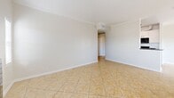 Located at 18540 Citronia St in Los Angeles, CA, this 2-bedroom, 4-bathroom residence offers a well-designed single-floor layout with a comfortable and functional living environment. The open-concept living and dining area is finished with light ceramic tile flooring, crown molding, and a ceiling fan, creating a bright and airy atmosphere. A striking black-tiled fireplace serves as a focal point, flanked by windows that invite natural light and outdoor views. The galley-style kitchen is equipped with white cabinetry, dark granite countertops, a double stainless steel sink, and black appliances including a gas range, refrigerator, and dishwasher — offering both style and practicality. The two bedrooms feature plush carpeting and mirrored sliding closet doors, with the primary bedroom providing a generous layout and ample natural light through horizontal blinds. Five closets throughout the unit ensure abundant storage. The four bathrooms are finished with tile flooring and clean, bright fixtures, including a tub-shower combination. A private balcony accessible from the living area provides an outdoor retreat. Hallways connect the spaces efficiently, completing a well-organized and comfortable floor plan.