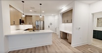 This thoughtfully designed 570-square-foot, one-bedroom, one-bathroom apartment offers a modern aesthetic with high-quality finishes throughout its single floor. The open-concept kitchen serves as the centerpiece of the living space, featuring flat-front cabinetry in a warm wood tone, white quartz countertops, a large center island with an undermount sink, and a full suite of stainless steel appliances including a refrigerator with ice maker, range, microwave, and dishwasher. Globe pendant lights add a contemporary touch above the island. A built-in desk nook provides a practical workspace near the entryway. Light wood-look luxury vinyl plank flooring flows seamlessly throughout the unit, creating a cohesive and clean look. The 140-square-foot primary bedroom is bright and airy, with a ceiling fan, natural light from a large window with roller shade, and direct access to the bathroom and closet. The bathroom makes a bold design statement with navy blue vanity cabinetry, a dual-sink white quartz countertop, matte black hardware and fixtures, an LED-lit mirror, and a tiled soaking tub with matching wall tile. Crisp white walls and clean-panel interior doors complete the modern, minimalist character of this well-appointed unit.