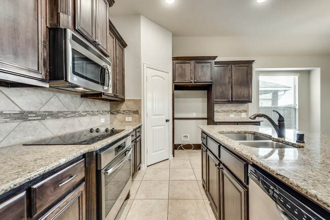 Entrance to kitchen with large island, built-in microwave, electric stove top and oven. - 2130 Hartley Dr