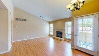 Located at 5121 Garfield Ave in Sacramento, CA, this single-floor, 3-bedroom, 3-bathroom home offers a well-designed layout with consistent warm-toned finishes throughout. Hardwood flooring flows seamlessly across all living spaces, complementing the neutral beige walls and white trim that give the home a clean, cohesive aesthetic.

The open living room serves as the heart of the home, anchored by a tile-surround fireplace with a raised hearth and flanked by multiple windows that invite abundant natural light. An elegant chandelier marks the adjacent dining area, which connects directly to the kitchen. The kitchen features white cabinetry, granite countertops, a peninsula breakfast bar, black appliances including a range and refrigerator, and a skylight overhead that bathes the space in natural light.

Each of the three bedrooms continues the hardwood flooring theme. The primary bedroom includes a sliding glass door leading to a private balcony with tree-lined views, while additional bedrooms offer generous windows and mirrored closet doors. Two closets provide practical storage throughout the unit.

The three bathrooms are appointed with sliding glass shower enclosures and hardwood-style flooring, maintaining design consistency. This well-maintained home presents a comfortable and functional living environment in Sacramento's Arden-Arcade area.