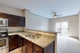 Located at 2303 Louisiana St in Houston, TX, this one-bedroom, one-bathroom unit offers a thoughtfully designed single-floor layout. The open-concept living and dining area is anchored by plush carpeting, crown molding, and a ceiling fan, creating a comfortable and cohesive space. A sliding glass door leads to a private balcony that overlooks a community pool, filling the room with natural light and pleasant outdoor views.

The kitchen is well-appointed with rich dark wood cabinetry, granite countertops, a double stainless steel sink, and a full suite of stainless steel appliances including a refrigerator, range, microwave, and dishwasher. Track lighting and hardwood-style flooring complete the kitchen's polished, functional aesthetic. A peninsula counter opens directly to the living area, reinforcing the open-plan feel.

The bedroom is a generously proportioned retreat featuring soft carpeting, a ceiling fan, and a window with natural light. It provides direct access to both a full bathroom and a spacious walk-in closet outfitted with wire shelving and hanging rods. Two additional closets throughout the unit offer ample storage. A dedicated laundry area and a formal entrance round out the unit's practical and well-organized floor plan.