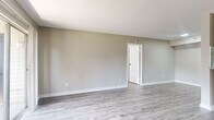 Located at 2700 Westridge St in Houston, TX, this two-bedroom, two-bathroom residence offers a well-organized single-level layout with a clean, modern aesthetic throughout. Durable wood-style flooring runs consistently across all living areas, complementing the neutral gray tones of the walls and crisp white trim.

The living room is a bright, open space anchored by sliding glass doors that lead to a private balcony, allowing natural light to fill the room. Adjacent to the living area, the combined dining and kitchen space features a galley-style kitchen equipped with gray cabinetry, granite countertops, a subway tile backsplash, and black appliances including a range and refrigerator.

Both bedrooms are generously proportioned, each fitted with a ceiling fan and natural light from windows with blinds. The spacious primary bedroom includes its own dedicated closet. The two bathrooms mirror each other in design, each offering a tub/shower combination, granite-topped vanity, and wood-style flooring for a cohesive look.

A hallway connects the private areas of the home, with additional closets providing ample storage. An in-unit laundry area adds everyday convenience. The layout is efficient and functional, making thoughtful use of every area throughout the home.