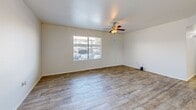 Located at 5060 W Hacienda Ave in Las Vegas, NV, this single-story 2-bedroom, 2-bathroom residence offers a clean, modern aesthetic throughout. Wood-look flooring flows seamlessly across every room, lending warmth and continuity to the entire space. The open-concept living and kitchen area forms the heart of the home, with the spacious living room featuring a ceiling fan and a large window that invites natural light. The kitchen is well-equipped with white shaker cabinetry, light quartz countertops, a subway tile backsplash, and a full suite of stainless steel appliances including a gas range, microwave, dishwasher, and refrigerator. A peninsula countertop provides convenient additional workspace and casual seating. Both bedrooms are generously sized, each featuring ceiling fans or overhead lighting and windows that bring in natural light. The primary bedroom includes a large walk-in closet with dual hanging rods and ample shelving. Both bathrooms are finished in a consistent, clean style with white vanities, quartz countertops, large mirrors, and tiled tub-shower combinations. The entry foyer offers a welcoming introduction to the home with a bright window and direct door access.