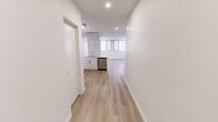 Located on the 10th floor at 835 8 Ave SW in the heart of Calgary's downtown core, this well-appointed 2-bedroom, 2-bathroom unit offers a thoughtfully designed layout with modern finishes throughout. Light hardwood-style flooring flows seamlessly across the entire unit, complementing the crisp white walls and recessed lighting that give the space a bright, contemporary feel.

The open-concept kitchen is equipped with stainless steel appliances — including a full-size refrigerator, electric range, and over-the-range microwave — paired with sleek white cabinetry, white quartz countertops, and a classic tile backsplash. The kitchen connects naturally to the living area, which benefits from large windows dressed with vertical blinds that invite generous natural light.

The spacious primary bedroom features wraparound windows on two walls, flooding the room with daylight, while the second bedroom also enjoys window access and includes a built-in closet for practical storage. Both bathrooms are finished in a clean, all-white palette with tile flooring, a soaker tub-shower combination, white vanity, and chrome fixtures. A functional hallway connects all areas of the unit efficiently. The overall ambiance is fresh, modern, and move-in ready.