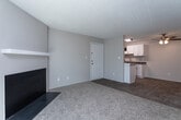 Located in Greensboro, NC, this single-floor residence offers a functional and well-organized layout across multiple rooms. The living area serves as a central gathering space, featuring plush carpeting, a wood-burning fireplace with a classic surround, and a large sliding glass door fitted with vertical blinds that allows abundant natural light and outdoor views. Adjacent to the living area, the dining and entry space flows into a galley-style kitchen equipped with white shaker cabinetry, granite-look countertops, black appliances including an electric range and refrigerator, a double sink, and light wood-look flooring throughout. A ceiling fan adds comfort to the dining area. The bedrooms are carpeted and finished with neutral tones; one bedroom benefits from dual windows that bring in natural light and views of surrounding greenery, while others feature single windows. Textured ceilings are consistent throughout the home. Two full bathrooms serve the residence — one includes a tub-shower combo with chrome fixtures and a curtain rod, while the second features a clean white tub-shower unit with tile flooring. The overall design is clean and neutral, providing a versatile canvas well-suited for a variety of living arrangements.