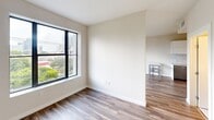 Located at 500 North Andrews Avenue in the heart of Fort Lauderdale, FL, this one-bedroom, one-bathroom unit offers a clean, modern layout with thoughtful finishes throughout. The open-concept living and kitchen area is anchored by warm wood-style flooring and crisp white walls, creating a bright and inviting atmosphere. Large black-framed windows flood the space with natural light while framing views of the surrounding Fort Lauderdale cityscape and lush greenery below. The kitchen features stainless steel appliances, a stove, refrigerator, and a peninsula-style counter ideal for casual dining or meal prep. The spacious bedroom is generously proportioned, featuring the same wood-style flooring and neutral tones that carry throughout the unit. A dedicated walk-in closet with built-in wire shelving provides ample storage and organization space. The bathroom is finished to a high standard, showcasing large-format marble-style floor and wall tiles, a soaking tub with an overhead shower, a sleek floating vanity with warm wood accents, and an illuminated mirror. Clean lines and a neutral palette give the bathroom a spa-like quality. This well-appointed unit combines contemporary design with functional living in one of Fort Lauderdale's vibrant urban neighborhoods.