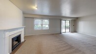 Located at 985 N Broadway in De Pere, Wisconsin, this well-appointed 2-bedroom, 2-bathroom unit offers a comfortable and functional single-floor layout. The expansive living room serves as the heart of the home, highlighted by a classic fireplace, soft neutral carpeting, and generous natural light from large windows and a sliding glass door that opens to an outdoor area with greenery views. The open connection to a secondary living space adds versatility to the floor plan.

The kitchen features wood-look vinyl flooring, white cabinetry, and stainless steel appliances including a full-size refrigerator, providing a clean and practical cooking environment.

Both bedrooms are carpeted and bathed in natural light through window treatments. The spacious primary bedroom offers generous square footage, while the second bedroom is well-sized and equally bright. Each bedroom benefits from ample closet storage, including a double-door closet in one room.

The two bathrooms are tastefully updated, featuring white subway tile, white vanities with quartz-style countertops, matte black hardware and fixtures, large mirrors with modern lighting, and wood-look flooring. One bathroom includes a full tub-shower combo with a grab bar. A hallway connects the bedrooms and bathrooms, keeping the layout cohesive and accessible.