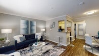 This single-floor residence offers a thoughtfully designed layout that balances comfort and functionality. The open-concept living area serves as the heart of the home, showcasing warm hardwood-style flooring, elegant crown molding, and neutral gray walls that create a versatile backdrop. Large windows allow natural light to fill the space, enhancing the bright and welcoming atmosphere. A breakfast bar with granite-style countertop seamlessly connects the living area to the kitchen, providing a casual dining and entertaining option.

The galley kitchen is efficiently organized, featuring white cabinetry, granite-style countertops, and a full suite of appliances including a gas range and dishwasher. Ample cabinet and counter space ensures practical everyday use.

The bedroom is a serene retreat, highlighted by plush carpeting, a ceiling fan, and generous windows dressed with blinds and curtains for adjustable light control. A walk-in closet offers convenient storage, adding to the room's functionality.

The bathroom features a granite-style vanity countertop, white cabinetry, wood-style flooring, and a full tub-shower combination, delivering a clean and practical design. Throughout the residence, a cohesive neutral color palette and consistent finishes create a polished, move-in-ready aesthetic.