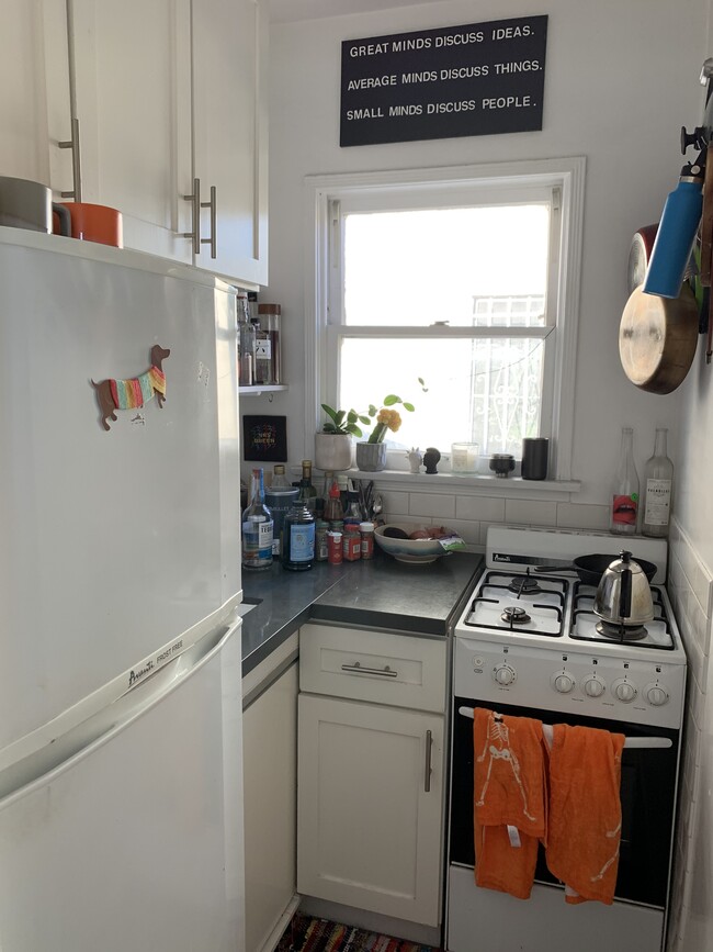 The kitchen! European style space with a gas stove, Corian countertop, refrigerator, and lots of upd - 1607 Talmadge St