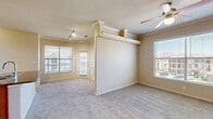 Located at 11575 Pearland Pkwy in Houston, TX, this two-bedroom, one-bathroom residence offers a well-organized single-story layout designed for comfortable everyday living. The combined kitchen and living room serves as the heart of the home, featuring a spacious carpeted living area with crown molding, ceiling fans, and multiple windows dressed with blinds that allow ample natural light. A dedicated track lighting fixture adds additional illumination to the living space, which also benefits from a glass-paneled exterior door.

The kitchen is equipped with warm honey-toned wood cabinetry, tile countertops with a decorative tile backsplash, and black appliances including a range, microwave, and refrigerator. Light ceramic tile flooring and a double-basin sink complete the functional space, which also includes a pantry closet.

Both bedrooms are carpeted and feature ceiling fans. The primary bedroom is generously sized and includes crown molding, while the second bedroom offers a built-in desk, open shelving, and a double-door closet with dual hanging rods for ample storage. The shared full bathroom includes a wood-toned vanity with a wide countertop, a tub-shower combination, tile flooring, and recessed lighting.