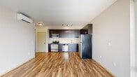 Located at 1450 N Prescott St in Portland, OR, this two-bedroom, two-bathroom unit offers a thoughtfully designed single-level layout. The open-concept kitchen and living area serves as the heart of the home, featuring rich dark espresso cabinetry extending to the ceiling, light quartz countertops, and a full suite of stainless steel appliances including a range, microwave, dishwasher, and refrigerator. Warm hardwood-style flooring runs throughout the main living areas, complementing the neutral-toned walls and creating a cohesive, modern aesthetic. Large floor-to-ceiling sliding glass doors in the living area flood the space with natural light and open onto a private balcony with pleasant outdoor views of the surrounding Portland neighborhood. A wall-mounted mini-split system provides efficient climate control. Both bedrooms are carpeted and feature windows that bring in natural light; the primary bedroom is generously sized, while the second bedroom offers comfortable proportions with a window and baseboard heating. Each bathroom is finished with dark vanity cabinetry, light countertops, tile-style flooring, and a full shower-tub combination. A hallway connects the living areas to the bedrooms and bathrooms, completing this well-appointed and functional layout.