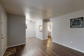 Located in Huntsville, Texas, this single-story 2-bedroom, 3-bathroom home offers a practical and well-organized layout. The living area welcomes you with rich, dark hardwood-style flooring, neutral gray walls, and a large front-facing window that fills the space with natural light. A ceiling fan adds comfort, while the open sight line connects the living room seamlessly to the dining area and kitchen beyond. The kitchen is accessible via a hallway pass-through, featuring cabinetry and a sink visible from the main living space. The bedrooms are carpeted for comfort and each equipped with ceiling fans and ample closet storage, with four closets distributed throughout the home. The primary bedroom is generously sized, offering a quiet retreat. The three bathrooms are clean and functional, featuring white vanities with integrated sinks, full tub-shower combinations, and wood-style flooring. A hallway connects the main living spaces to the private areas of the home. Neutral tones and consistent finishes throughout lend the space a cohesive, move-in ready feel. With a compact yet efficient footprint, this home in Huntsville provides comfortable everyday living in a straightforward, single-level design.