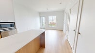 Located at 6320 Shakespeare St in Pittsburgh's East End, this thoughtfully designed one-bedroom, one-bathroom residence offers a clean, modern aesthetic throughout its efficiently arranged single-floor layout. Light hardwood flooring flows seamlessly across the entire living space, creating a warm and cohesive foundation.

The open-concept kitchen is a standout feature, equipped with stainless steel appliances including a gas range, refrigerator, and dishwasher. Two-tone cabinetry pairs white upper cabinets with warm wood lower cabinets, complemented by a classic white subway tile backsplash and a sleek white-topped kitchen island that doubles as a prep and dining space. A built-in entry bench with storage cubbies and a wall-mounted coat hook rail adds practical organization near the entry.

The bedroom is a bright, tranquil retreat featuring a large window that frames views of the surrounding Pittsburgh neighborhood and skyline. The room offers generous proportions with access to a dedicated closet. Adjacent to the bedroom, the bathroom is finished with large-format grey floor tiles, white subway-tiled walls, and a glass-enclosed walk-in shower, delivering a crisp, contemporary feel. Recessed lighting throughout the main living area adds to the clean, modern ambiance of this well-appointed residence.