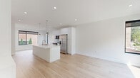 Located at 616 W Fulton St in Grand Rapids, Michigan, this contemporary three-story residence offers four bedrooms and five bathrooms across a well-organized, efficiently designed floor plan. The main living level showcases an open-concept kitchen and living area finished with light hardwood flooring throughout. The kitchen features sleek white flat-front cabinetry, a light blue subway tile backsplash, stainless steel appliances including a French door refrigerator and range, and a large white quartz waterfall island with an undermount sink and modern pendant lighting. Large black-framed windows invite abundant natural light and provide leafy outdoor views. The bathrooms maintain the home's clean aesthetic with light wood flooring and crisp white finishes. Each bedroom is bright and airy, with large black-framed windows framing tree-lined views of the surrounding neighborhood. The primary bedroom offers a comfortable footprint with ample natural light. A dedicated laundry room houses a full-size side-by-side washer and dryer with built-in shelving. Three closets and multiple hallways provide practical storage throughout. The home's consistent use of white walls, light hardwood floors, and modern fixtures creates a cohesive, minimalist aesthetic across all three floors.