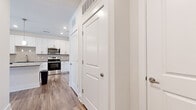 Located in Port Wentworth, Georgia, this well-appointed one-bedroom, one-bathroom unit offers a thoughtfully designed single-floor layout with modern finishes throughout. The open-concept kitchen and living area serves as the heart of the home, showcasing crisp white shaker cabinetry, granite countertops, a central island with pendant lighting, and a full suite of stainless steel appliances including a range, microwave, dishwasher, and refrigerator. Wood-look luxury vinyl plank flooring runs throughout the main living spaces, lending warmth and continuity to the open floor plan. The living area benefits from abundant natural light through large windows and a glass door that opens to the outside. The bedroom is a comfortable retreat featuring plush carpeting, a generous window with blinds, and direct access to a spacious walk-in closet outfitted with wire shelving. The bathroom is finished with wood-look flooring, a granite-topped vanity with contemporary cabinetry, and a full soaking tub with shower. A dedicated entrance and additional closet space round out this efficiently planned home, making it an excellent option for those seeking modern comfort and style.