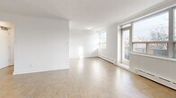 This well-appointed 2-bedroom, 1-bathroom unit at 3388 Bathurst Street, Unit 202, in Toronto's vibrant midtown neighbourhood offers a thoughtfully laid-out single-floor living space. Classic parquet wood flooring runs throughout the unit, lending warmth and character to every room.

The open living and dining area is generously sized, filled with natural light through large windows that frame views of the surrounding neighbourhood. A door leads directly to a private balcony, extending the living space outdoors. Baseboard heating units line the walls beneath the windows, ensuring comfortable year-round living.

The kitchen is functionally positioned adjacent to the dining area, providing a practical and efficient layout. Both bedrooms are well-proportioned, with the primary bedroom offering a spacious footprint, large windows overlooking the street, and ample wall space. The second bedroom also benefits from natural light and parquet flooring consistent with the rest of the unit.

The bathroom features a clean, modern design with white subway tile surrounding the soaker tub and a white vanity with an integrated sink, creating a crisp and polished finish. A connecting hallway ties all rooms together efficiently. The overall aesthetic is bright, neutral, and move-in ready.