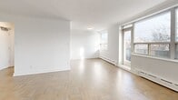 This well-appointed 2-bedroom, 1-bathroom unit at 3388 Bathurst Street, Unit 202, in Toronto's vibrant midtown neighbourhood offers a thoughtfully laid-out single-floor living space. Classic parquet wood flooring runs throughout the unit, lending warmth and character to every room.

The open living and dining area is generously sized, filled with natural light through large windows that frame views of the surrounding neighbourhood. A door leads directly to a private balcony, extending the living space outdoors. Baseboard heating units line the walls beneath the windows, ensuring comfortable year-round living.

The kitchen is functionally positioned adjacent to the dining area, providing a practical and efficient layout. Both bedrooms are well-proportioned, with the primary bedroom offering a spacious footprint, large windows overlooking the street, and ample wall space. The second bedroom also benefits from natural light and parquet flooring consistent with the rest of the unit.

The bathroom features a clean, modern design with white subway tile surrounding the soaker tub and a white vanity with an integrated sink, creating a crisp and polished finish. A connecting hallway ties all rooms together efficiently. The overall aesthetic is bright, neutral, and move-in ready.