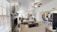 Located in Yukon, Oklahoma, this single-story, 2-bedroom, 2-bathroom home offers a well-designed open floor plan that maximizes comfort and functionality. The combined living and dining area is a standout feature, anchored by a classic fireplace with a gray wood surround and complemented by soaring vaulted ceilings with ceiling fans. Soft carpet flooring flows throughout the living spaces, while the dining area is bathed in natural light from large windows with wood-slat blinds.

The kitchen is bright and modern, showcasing white shaker-style cabinetry, white quartz countertops, a subway tile backsplash, stainless steel appliances, and tile flooring. A dedicated pantry and in-unit laundry room with washer/dryer hookups add convenience.

The primary bedroom features vaulted ceilings, carpet flooring, and direct access to a private bathroom and a walk-in closet. The en-suite bathroom includes a white vanity with quartz countertops, a tiled tub-shower combination, and large-format tile floors. The second bedroom is equally well-sized with a ceiling fan, ample natural light, and closet storage. Three closets total ensure generous storage throughout the home. The welcoming entrance rounds out this thoughtfully designed residence.