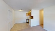 Located at 5461 Collins Mill Creek Drive in Milton, Florida, this single-floor residence offers a straightforward and functional layout designed for comfortable everyday living. The open-concept floor plan seamlessly connects the living area to the kitchen, creating a cohesive and practical space. The living area features neutral carpeting that adds warmth underfoot, while the transition to tile flooring marks the kitchen zone. The kitchen is equipped with warm-toned wood cabinetry, a built-in dishwasher, a sink, and a peninsula-style breakfast bar that provides both additional counter space and a natural divider between the cooking and living areas. The textured ceiling throughout adds a classic residential character, and recessed lighting ensures the space is well-lit. The neutral color palette of white and warm beige tones throughout the interior creates a clean, versatile canvas. The single-level design makes for easy navigation and accessibility. Overall, the space presents a tidy, move-in-ready environment well-suited for those seeking a practical and efficiently organized home in the Milton, FL area.