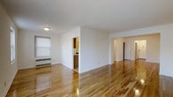 Located at 112 Hoyt Street in Stamford, Connecticut, this one-bedroom, one-bathroom residence offers a well-organized single-floor layout designed for comfortable everyday living. The interior is defined by beautiful, warm-toned hardwood floors that flow seamlessly throughout the space, reflecting natural light and adding a sense of openness and warmth to every room.

The main living area is generously proportioned, featuring clean white walls that create a bright and airy atmosphere. A window with a roller shade allows for adjustable natural light, while a baseboard radiator ensures year-round comfort. The open layout connects the living space to a hallway that leads to the bedroom and bathroom, providing a logical and efficient flow throughout the unit.

The kitchen is positioned adjacent to the main living area and features warm wood cabinetry, offering practical storage and a classic aesthetic. A glimpse of colorful tile detail adds a touch of character to the kitchen space.

The bedroom is accessible via a wide hallway, with a paneled door providing privacy. The consistent hardwood flooring and white walls carry throughout, maintaining a cohesive and clean look across the entire residence. This home offers a straightforward, functional design with timeless finishes in a convenient Stamford location.