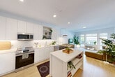 This well-designed one-bedroom, one-bathroom unit offers a thoughtfully arranged single-floor layout that maximizes its efficient footprint. The open-concept kitchen and living area form the heart of the space, connected seamlessly by light wood flooring that runs throughout. The kitchen is outfitted with flat-front white cabinetry extending to the ceiling, stainless steel appliances including a French door refrigerator, electric range, and over-the-range microwave, complemented by white quartz countertops and a subway tile backsplash. A freestanding island provides additional prep and storage space. Recessed lighting keeps the area bright and functional.

The living room benefits from a wide bank of windows that invite natural light and offer views of the surrounding streetscape. The bedroom is a generously sized retreat featuring dual windows, light wood flooring, a built-in closet, and ample room for a full furniture arrangement. The bathroom includes a soaking tub with shower, large-format neutral tile surround, a floating vanity with an undermount sink, and a wide mirror. Clean white walls and consistent finishes throughout contribute to a cohesive, modern aesthetic.