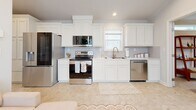 Located at 1009 Big Constellation Way in San Marcos, TX, this thoughtfully designed single-story home offers two bedrooms and one bathroom across a well-utilized floor plan. The open-concept layout seamlessly connects the living area to a fully equipped kitchen, which features white shaker-style cabinetry with crown molding detail, light countertops, a full suite of stainless steel appliances, and a window above the sink that brings in natural light. The living space flows naturally from the kitchen, creating a cohesive and functional common area. The primary bedroom is a comfortable retreat with crown molding, a ceiling fan, multiple windows for natural light, and a closet. The second bedroom mirrors this bright, airy character, featuring additional windows, crown molding, and its own closet, making it equally suitable as a guest room or home office. The shared bathroom is efficiently designed with tile flooring, a vanity with ample storage, a toilet, and a glass-enclosed walk-in shower with tile surround and a window for ventilation. Neutral tones, light-toned flooring, and recessed lighting carry throughout the home, creating a clean, consistent aesthetic. This home offers a practical and comfortable layout well-suited for everyday living in the heart of San Marcos.